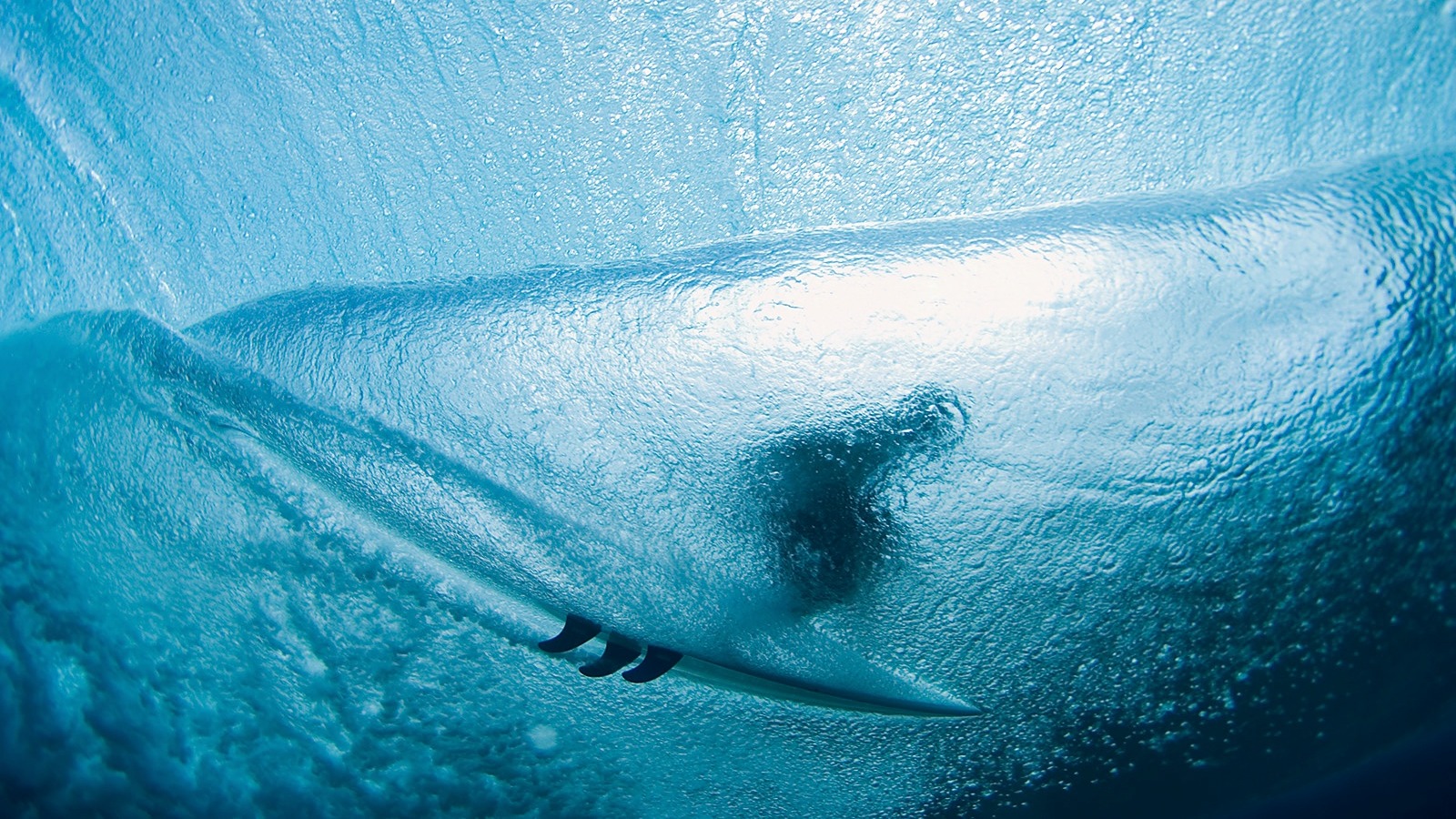 Vue sous une vague, planche de surf visible